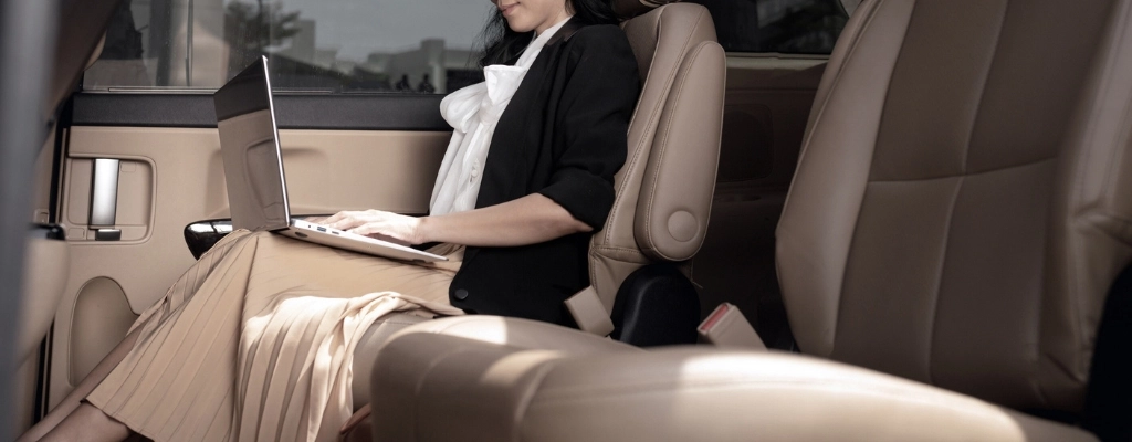 businesswoman sitting comfortably on the back seat of an airport limousine