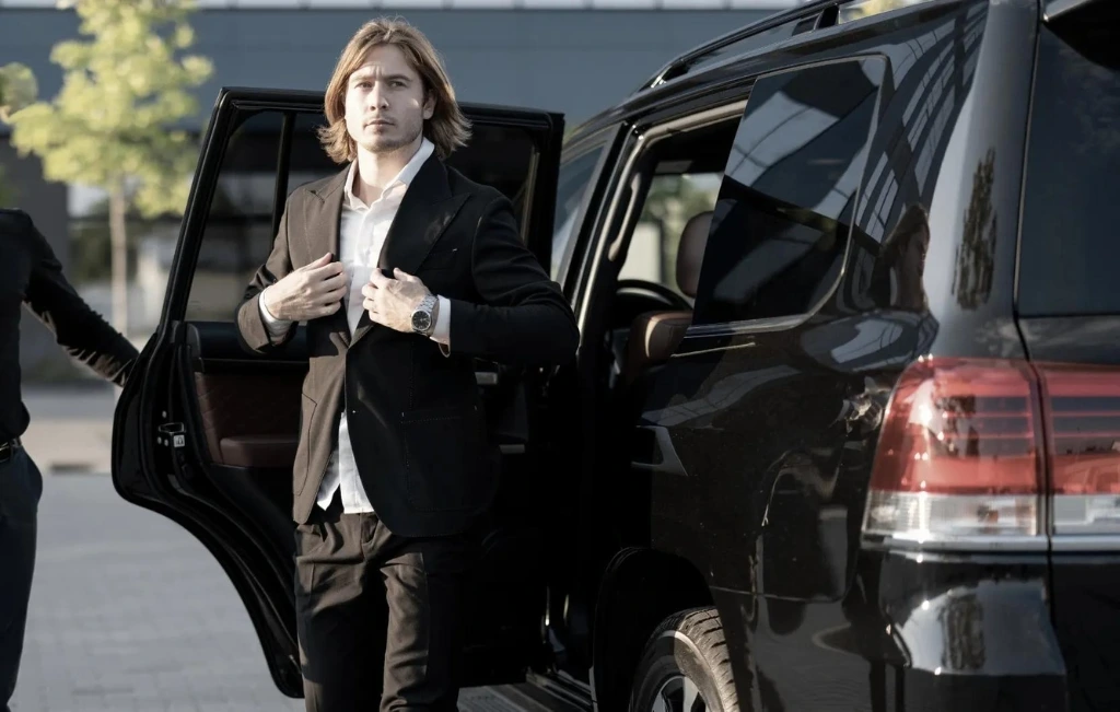 Chauffeur helps a businessman to get out of the car