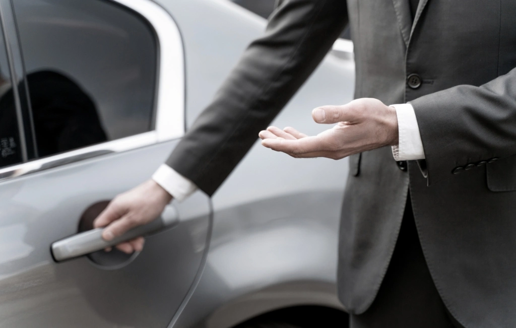 male limousine driver in suit about to open the car door