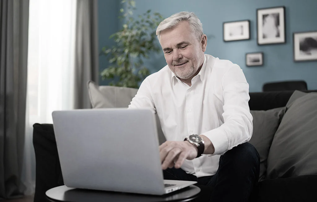 Middle-aged man working on laptop booking a transfer