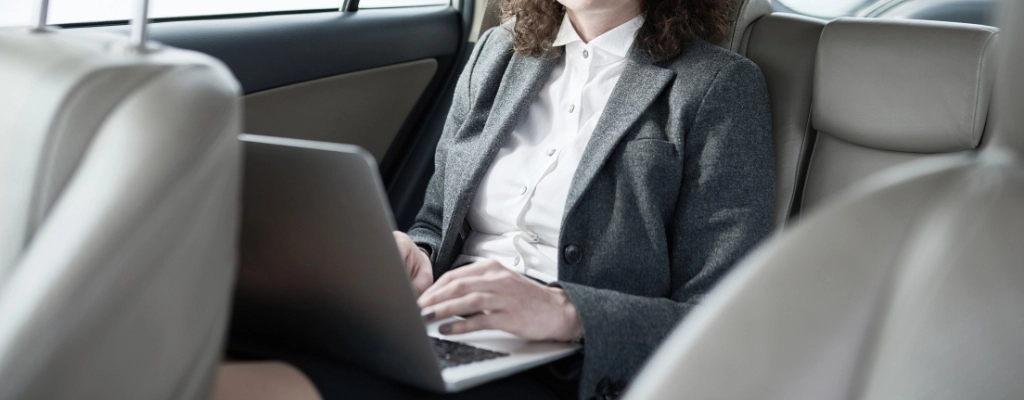 woman inside car sitting comfortably during her airport limousine service