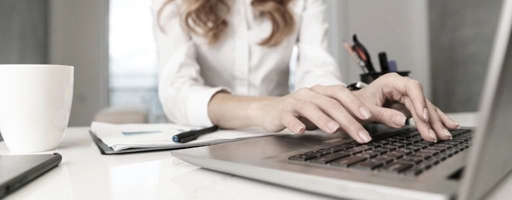 woman on laptop booking her airport limousine service